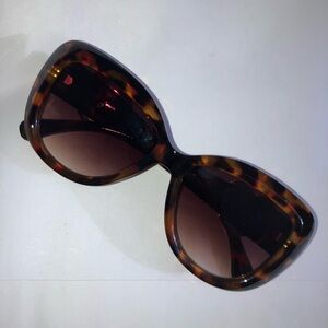 Tortoise shell oversize sunglasses with gold heart-shaped detail
